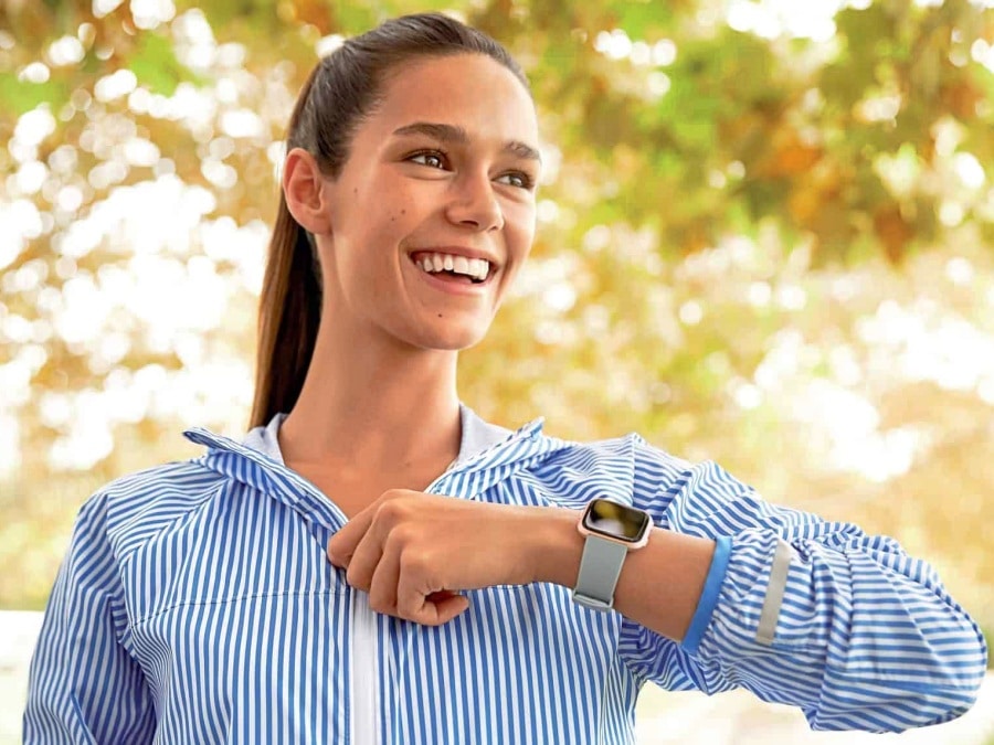 mujer sonriendo y mostrando su smartwatch