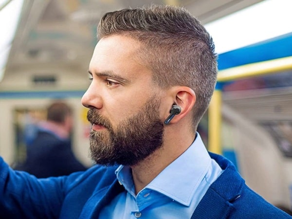 Hombre usando auriculares inalámbricos en el metro