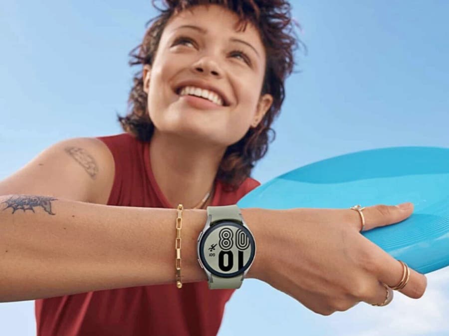 Chica en la playa sonriendo con un Samsung Galaxy Watch4